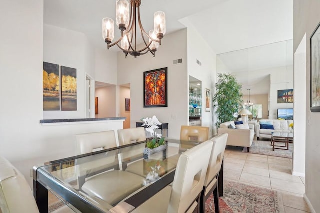 tiled dining room with high vaulted ceiling and a chandelier