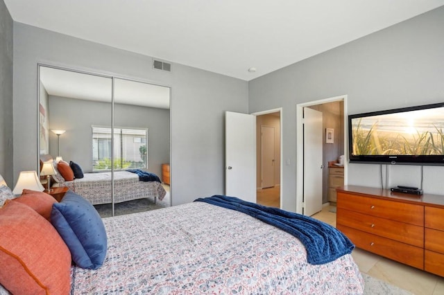 bedroom with ensuite bathroom and a closet