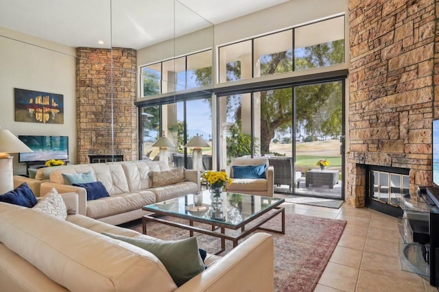 living room featuring a fireplace, light tile patterned flooring, and a high ceiling