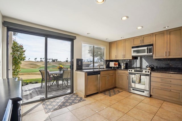 kitchen with light tile patterned flooring, appliances with stainless steel finishes, sink, and backsplash