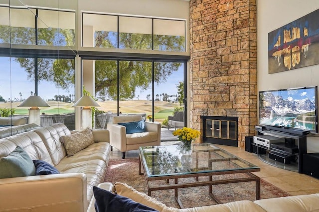 tiled living room featuring a towering ceiling and a fireplace