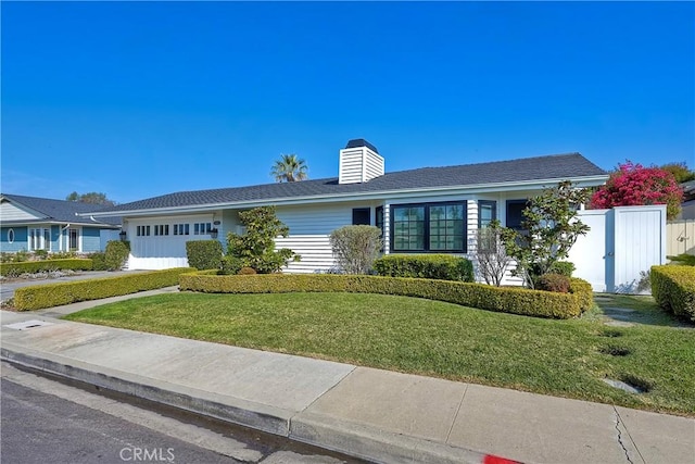 ranch-style home with a garage and a front lawn