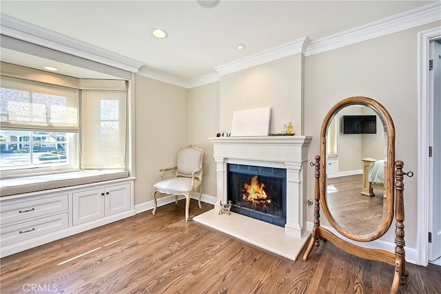 living area with ornamental molding and light wood-type flooring