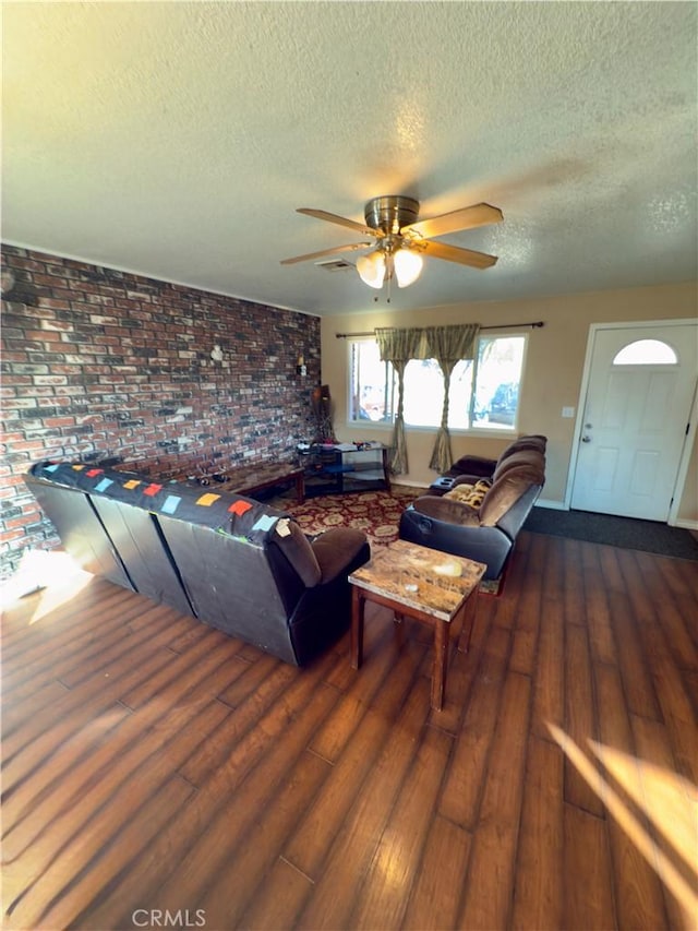 living room featuring ceiling fan, dark hardwood / wood-style floors, and a textured ceiling