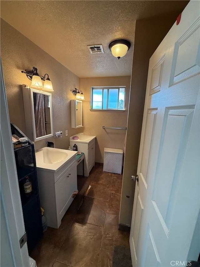 bathroom with vanity and a textured ceiling