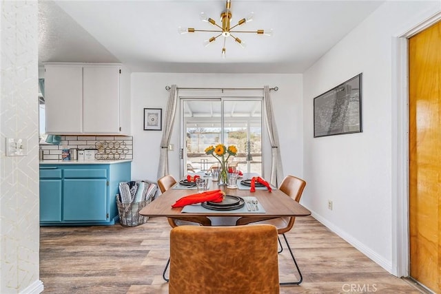 dining area with an inviting chandelier and light hardwood / wood-style floors