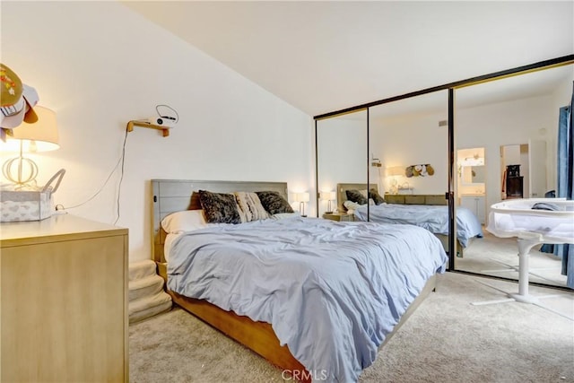 carpeted bedroom with vaulted ceiling and a closet