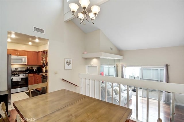 tiled dining space with beam ceiling, high vaulted ceiling, and a chandelier