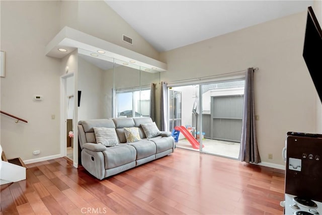 living room with wood-type flooring and high vaulted ceiling