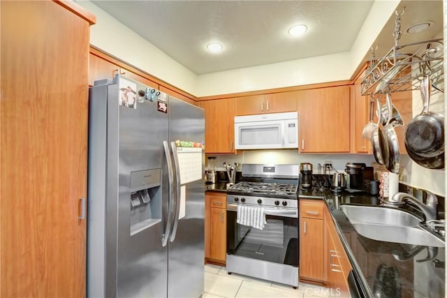 kitchen featuring stainless steel appliances, sink, and light tile patterned floors