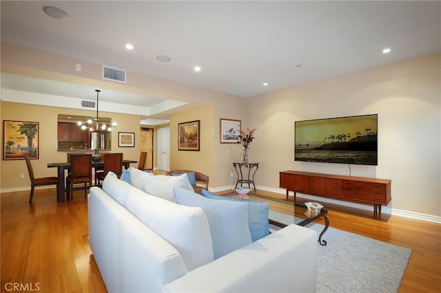 living room featuring an inviting chandelier and light hardwood / wood-style flooring