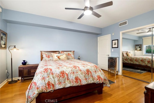 bedroom with hardwood / wood-style flooring, ceiling fan, and a closet