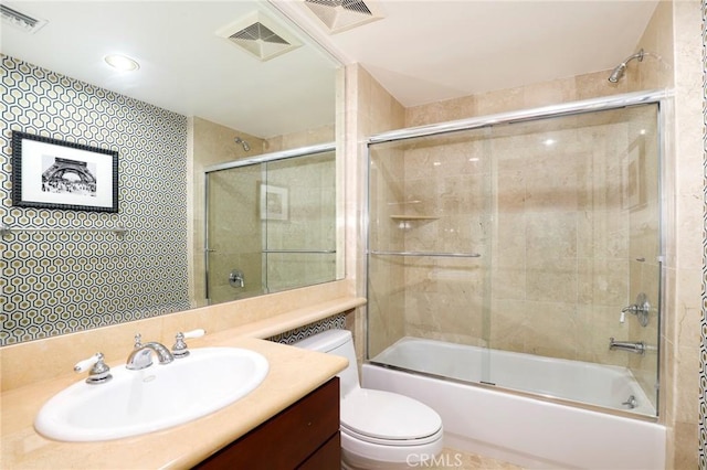 full bathroom featuring bath / shower combo with glass door, vanity, and toilet