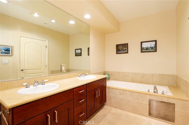 bathroom featuring tile patterned floors, vanity, and tiled tub