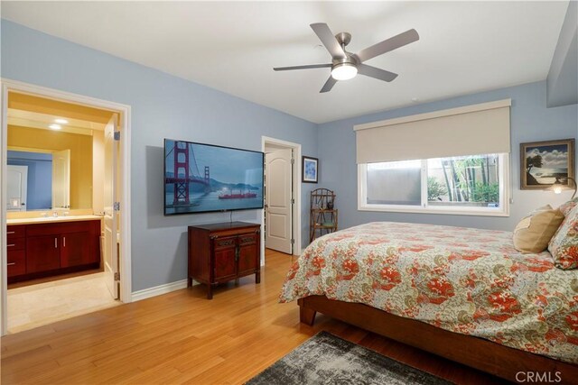 bedroom with ensuite bathroom, sink, ceiling fan, and light hardwood / wood-style flooring