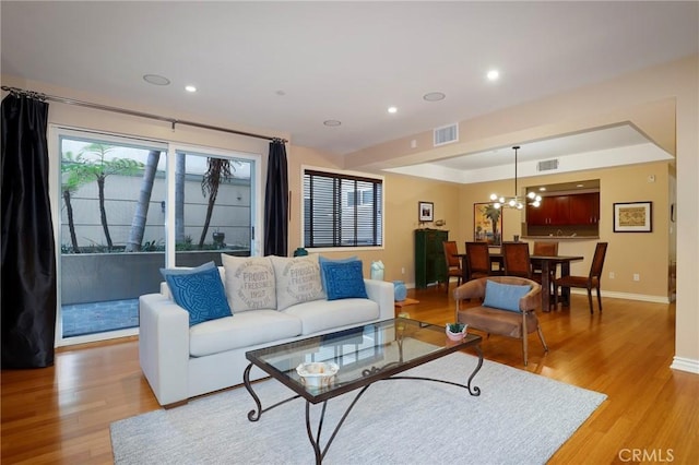 living room featuring a chandelier and light hardwood / wood-style floors