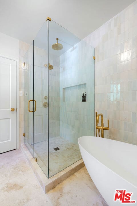 bathroom featuring tile walls and shower with separate bathtub