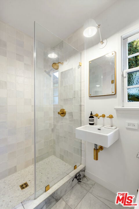 bathroom featuring sink and a tile shower