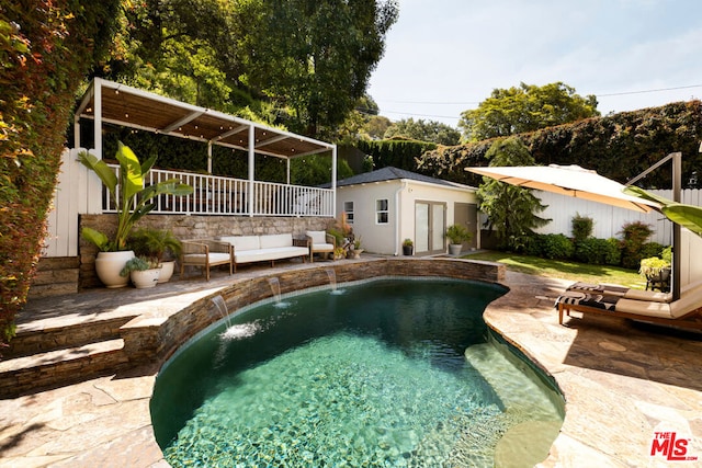 view of swimming pool featuring a patio, an outbuilding, and pool water feature