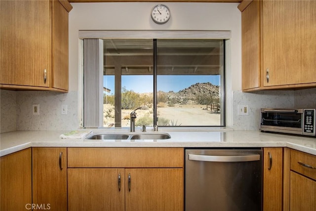 kitchen with tasteful backsplash, stainless steel dishwasher, and sink