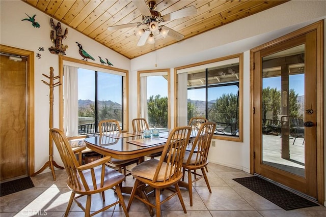 sunroom with vaulted ceiling, a mountain view, a healthy amount of sunlight, and wooden ceiling