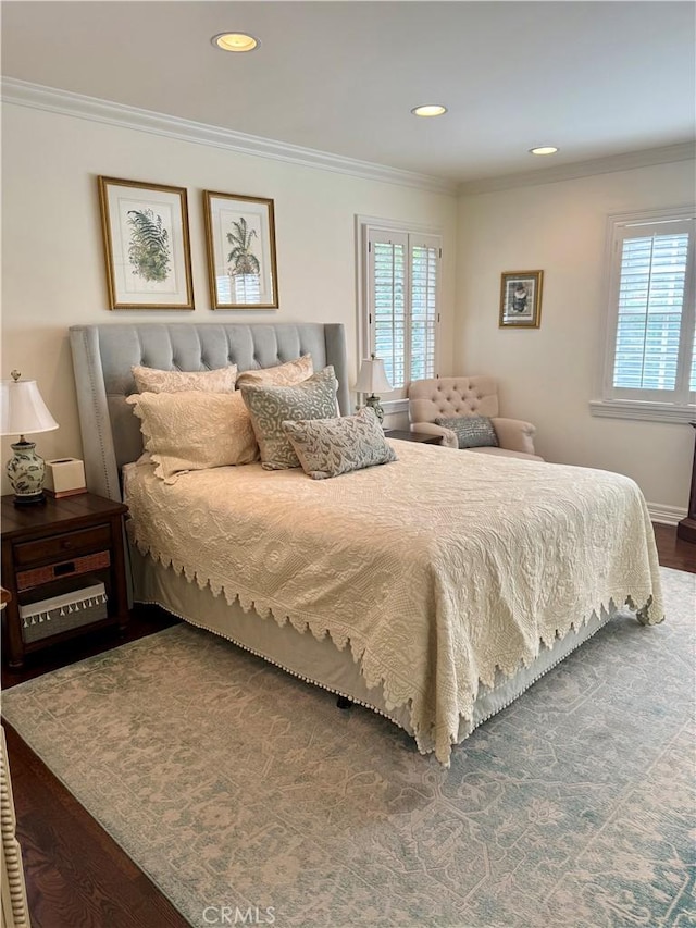 bedroom with multiple windows, wood-type flooring, and ornamental molding