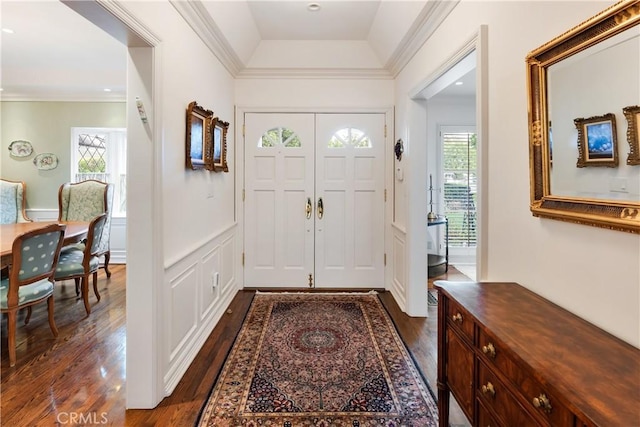 foyer with ornamental molding and dark wood-type flooring