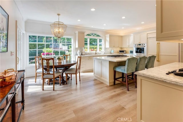 kitchen featuring tasteful backsplash, stainless steel appliances, light stone counters, pendant lighting, and ornamental molding