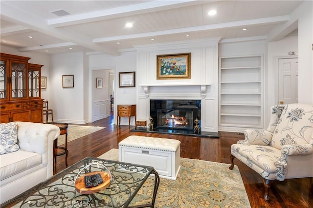 living room featuring beam ceiling, dark hardwood / wood-style flooring, and built in features