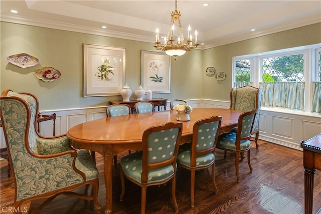 dining area featuring dark hardwood / wood-style flooring, ornamental molding, an inviting chandelier, and a tray ceiling