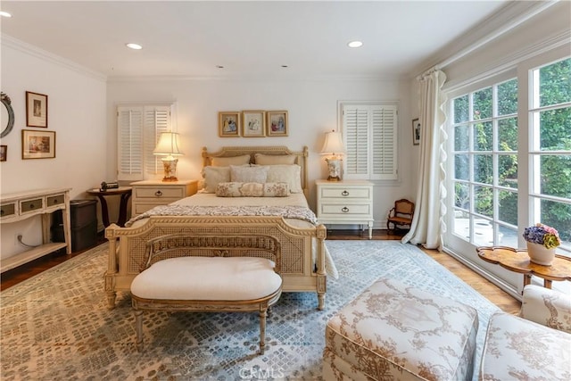 bedroom featuring multiple windows, crown molding, and light wood-type flooring