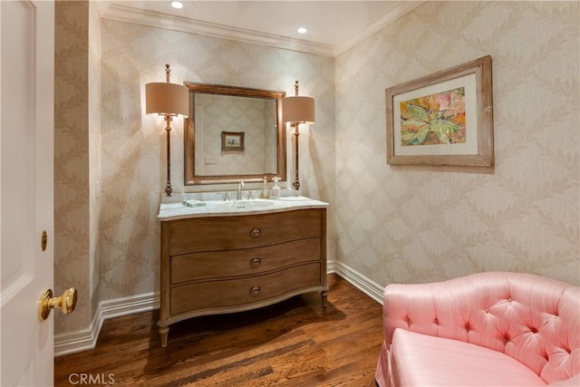 bathroom featuring hardwood / wood-style floors, crown molding, and sink