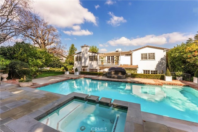 view of swimming pool with an in ground hot tub, a patio, and grilling area