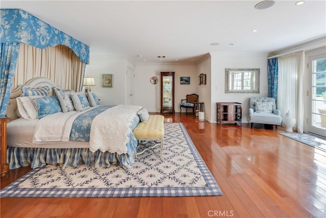 bedroom featuring hardwood / wood-style floors, access to exterior, and ornamental molding