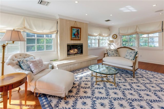 living area with crown molding and hardwood / wood-style floors