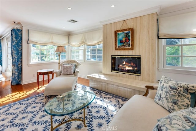 sitting room with hardwood / wood-style floors and ornamental molding