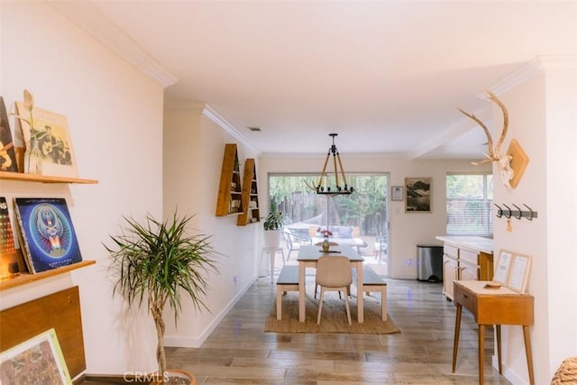 dining area featuring crown molding, hardwood / wood-style floors, and a notable chandelier