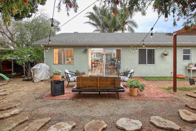 rear view of property with an outdoor living space and a patio area