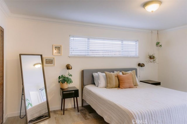 bedroom featuring ornamental molding and light hardwood / wood-style flooring