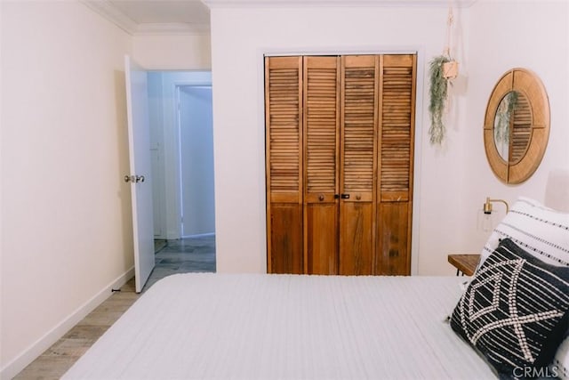 bedroom featuring ornamental molding, light hardwood / wood-style floors, and a closet