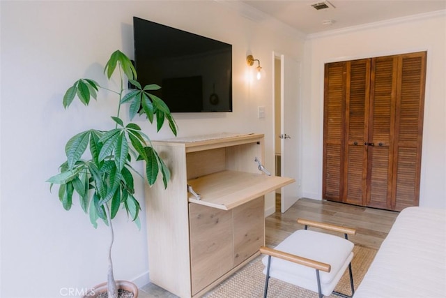 bedroom featuring ornamental molding, a closet, and light hardwood / wood-style flooring