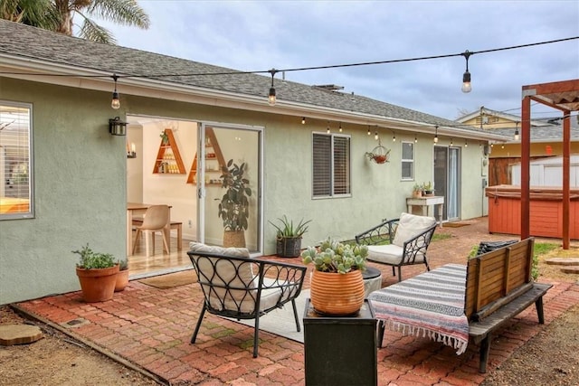 back of house with a hot tub and a patio