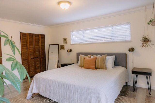 bedroom with hardwood / wood-style floors, crown molding, and a closet