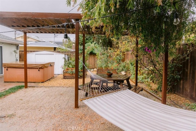 view of patio with a hot tub and a storage unit