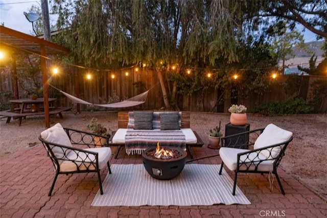 patio terrace at dusk featuring an outdoor living space with a fire pit