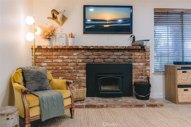 sitting room with a fireplace and wood-type flooring