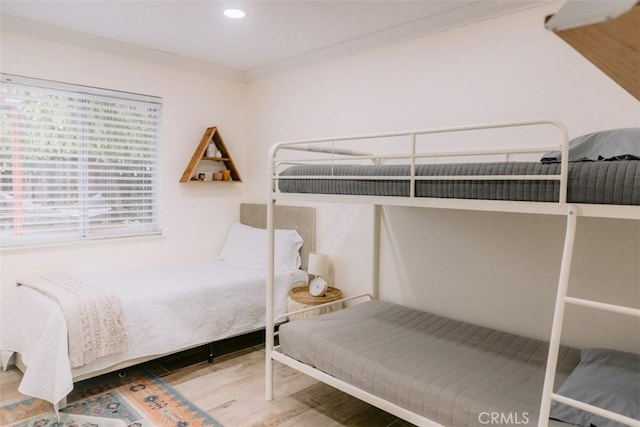 bedroom featuring crown molding and wood-type flooring