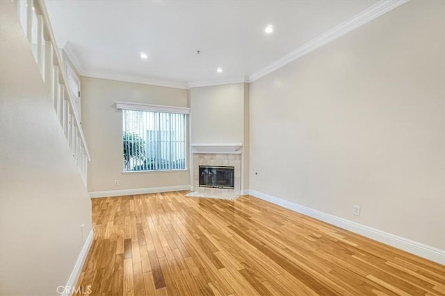 unfurnished living room with ornamental molding, a fireplace, and light hardwood / wood-style flooring