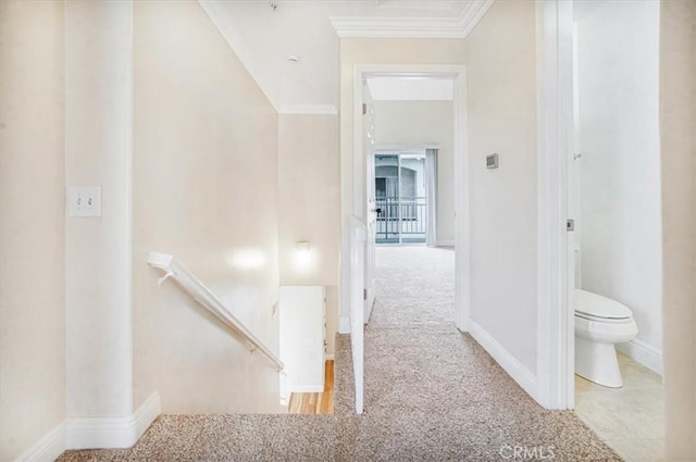 corridor featuring ornamental molding and light colored carpet