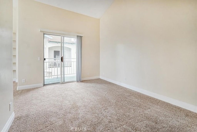 carpeted spare room with lofted ceiling